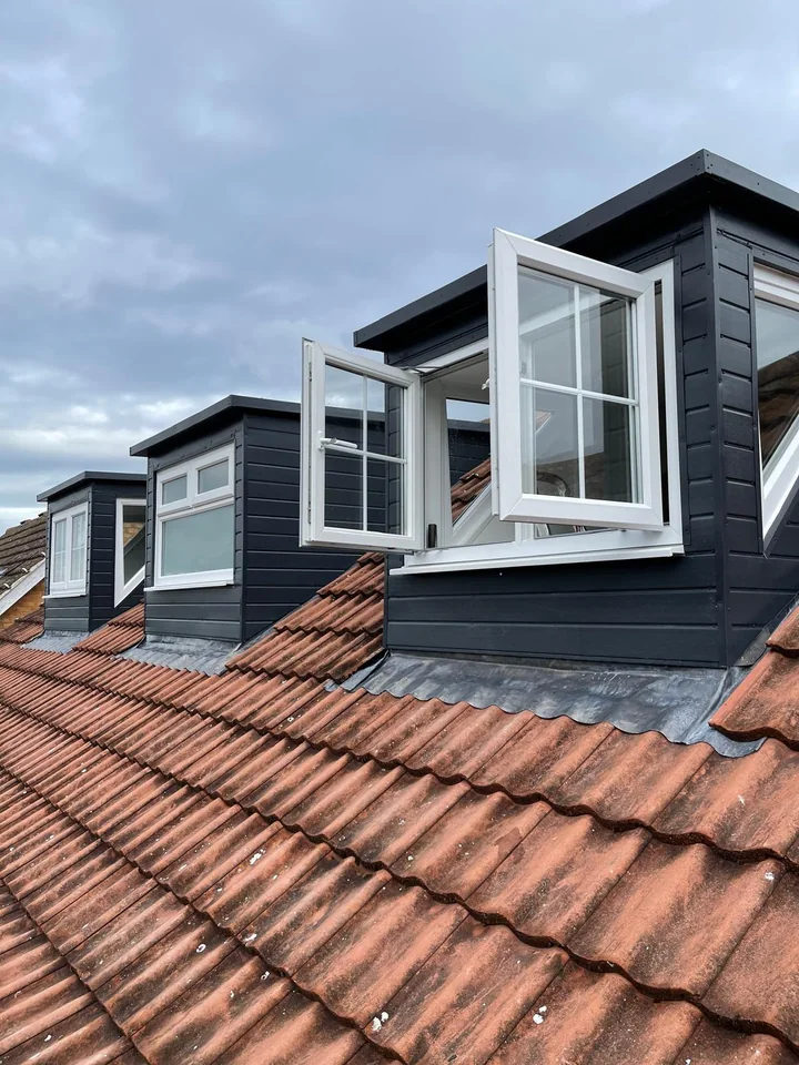 Row of new clad dormers on a terracotta roof